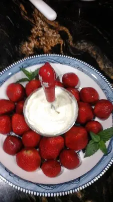 a plate of strawberries with a bowl of whipped cream at The Silk Pincushion in Golden
