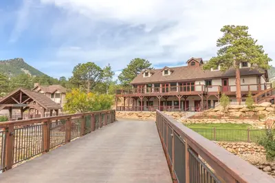 a wooden bridge leading to a large house at The Landing at Estes Park in Estes Park