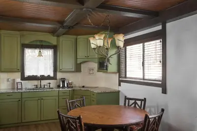 a kitchen with green cabinets and a wooden table at The Landing at Estes Park in Estes Park
