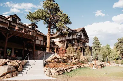 an exterior view of a house with a tree at The Landing at Estes Park in Estes Park