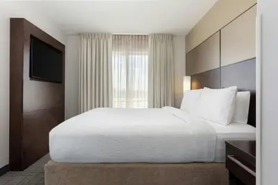 a hotel room with a large bed and a window at Residence Inn by Marriott Denver Central Park in Denver