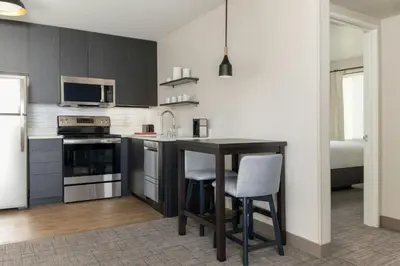 a kitchen with a table and chairs in a room at Residence Inn by Marriott Denver Central Park in Denver