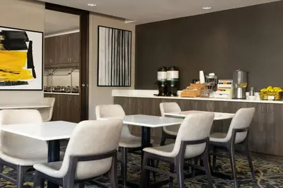 a dining room with white chairs and a table at Residence Inn by Marriott Denver Central Park in Denver