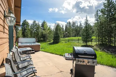 a grill and chairs on a patio with a view at Hohenmark Haus Home: Great Year-Round Location in Breckenridge