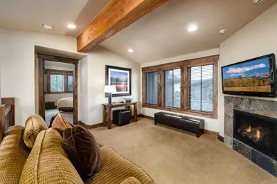 a living room with a couch and a fireplace at The Shores Riverside Townhome: Peaceful Luxury in Breckenridge