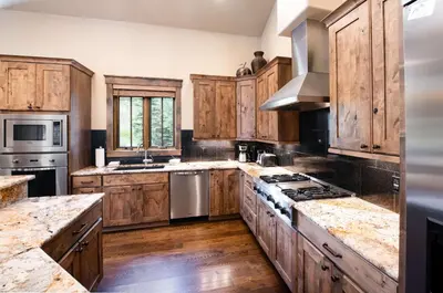 a large kitchen with wooden cabinets and stainless steel appliances at The Shores Riverside Townhome: Peaceful Luxury in Breckenridge