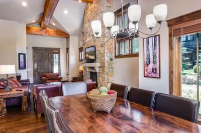 a dining room with a wooden table and a fireplace at The Shores Riverside Townhome: Peaceful Luxury in Breckenridge