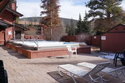 a patio with a pool and two chairs and a table at Mountainside Trailview Condo: Cozy Frisco Retreat in Frisco
