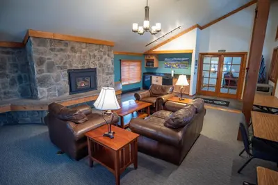 a living room with leather furniture and a stone fireplace at Mountainside Trailview Condo: Cozy Frisco Retreat in Frisco