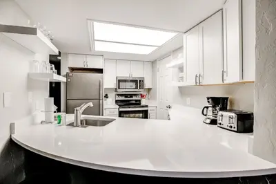 a white kitchen with a large white counter top at Mountainside Trailview Condo: Cozy Frisco Retreat in Frisco