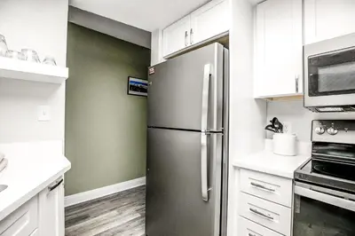a stainless steel refrigerator in a kitchen with white cabinets at Mountainside Trailview Condo: Cozy Frisco Retreat in Frisco