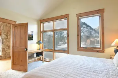 a bedroom with a bed and a large window at Mt. Victoria Lodge Penthouse Condo: Downtown, Hot Tub in Frisco