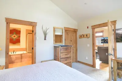a bedroom with a bed and a bathroom with a sink at Mt. Victoria Lodge Penthouse Condo: Downtown, Hot Tub in Frisco