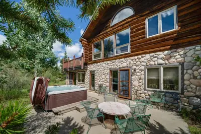 a house with a pool and a table and chairs at Swan River Lodge Home: Spacious, Hot Tub in Breckenridge