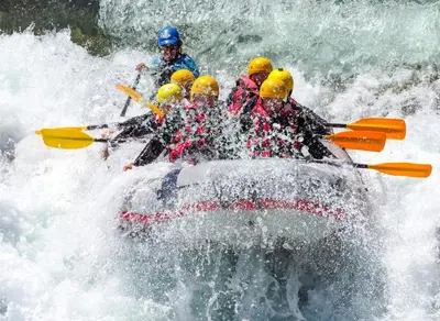 a group of people in a raft in a river at Crossroads Snowshoe Townhome: Great Views, On Rec Path in Summit Medical Center Heliport