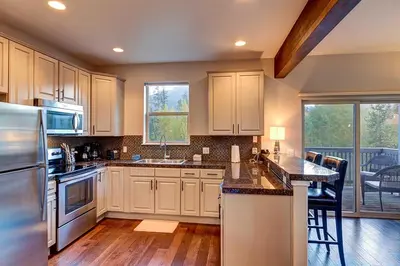a kitchen with white cabinets and a counter top at Crossroads Snowshoe Townhome: Great Views, On Rec Path in Summit Medical Center Heliport