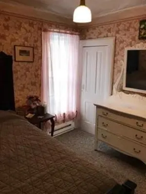 a bedroom with a bed and a dresser and a window at Historic Windsor in Silver Plume