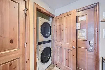 a laundry room with a washer and dryer next to a door at Highland Greens Lodge 210 Colorado in Breckenridge