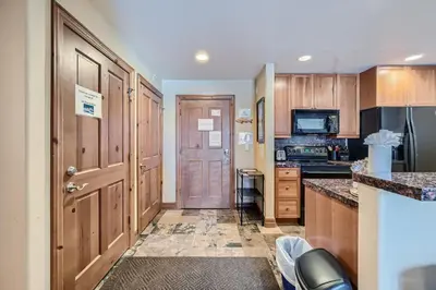 a large kitchen with wooden cabinets and a door at Highland Greens Lodge 210 Colorado in Breckenridge