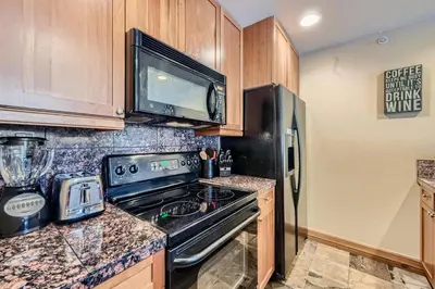 a kitchen with a stove and a microwave at Highland Greens Lodge 210 Colorado in Breckenridge