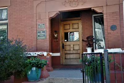a front door of a brick building with a sign on it at Off Broadway B & B in Denver