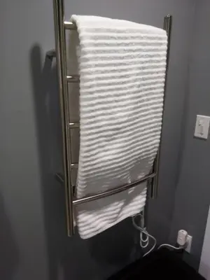 a towel rack with a stack of towels in a bathroom at Off Broadway B & B in Denver