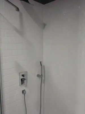 a shower stall with a hose in a bathroom at Off Broadway B & B in Denver