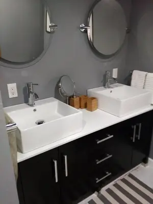 a bathroom with two sinks and two mirrors at Off Broadway B & B in Denver