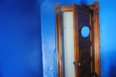 a wooden door with a mirror next to a blue wall at Off Broadway B & B in Denver