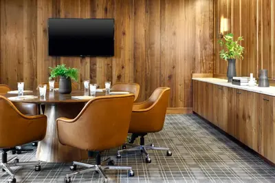 a conference room with a table and chairs and a television at Limelight Hotel Denver in Denver