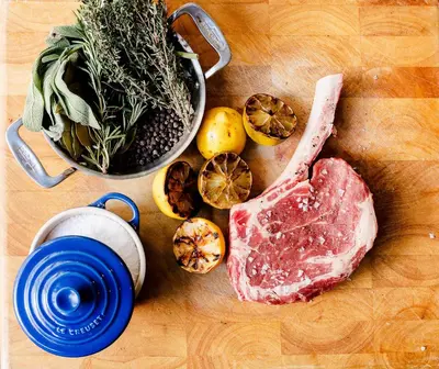 a cutting board with meat and vegetables and a pot of herbs at Limelight Hotel Denver in Denver