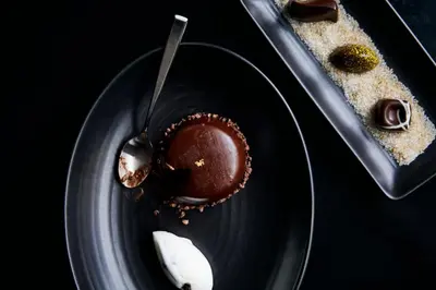 a chocolate cupcake on a plate with a spoon at Limelight Hotel Denver in Denver