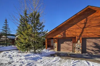 a log cabin with a pine tree in the snow at 127 Lookout Ridge Townhouse in Dillon