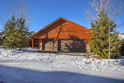 a wooden house with a garage in the snow at 127 Lookout Ridge Townhouse in Dillon