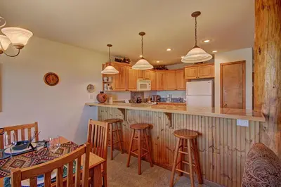 a kitchen with wooden cabinets and a bar with stools at 127 Lookout Ridge Townhouse in Dillon