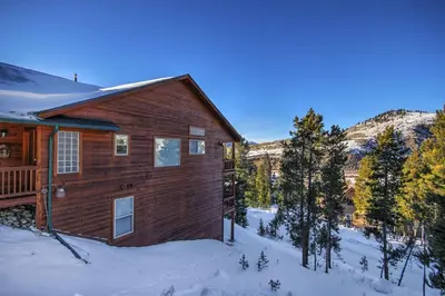 a log home in the snow with trees at 127 Lookout Ridge Townhouse in Dillon