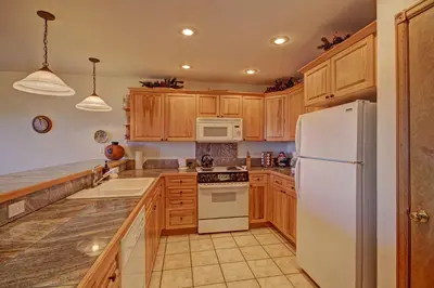 a kitchen with wooden cabinets and a white refrigerator at 127 Lookout Ridge Townhouse in Dillon
