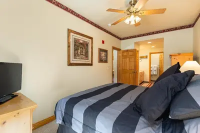 a bedroom with a bed and a flat screen tv at 5949 Hidden River Lodge Condo in Keystone