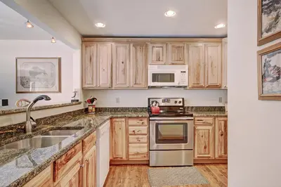 a kitchen with wooden cabinets and stainless steel appliances at Ffd7 Frostfire Condo in Keystone