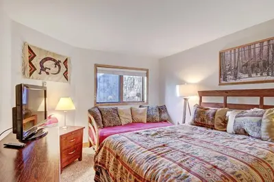 a bedroom with a bed and a desk with a television at Ffd7 Frostfire Condo in Keystone