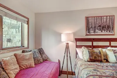 a bedroom with a bed and a lamp and a window at Ffd7 Frostfire Condo in Keystone