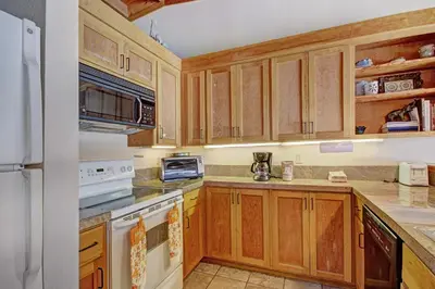 a kitchen with wooden cabinets and white appliances at 2035 Homestead Condo in Keystone