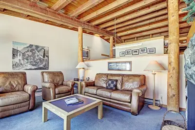 a living room with leather furniture and a table at 2035 Homestead Condo in Keystone
