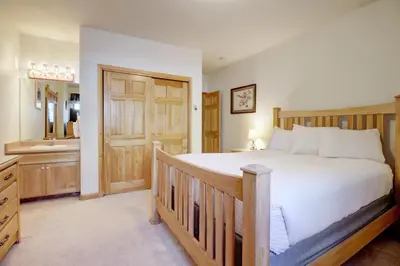 a bedroom with a large bed and a bathroom at 172 Sauterne Sanctuary Townhouse in Silverthorne