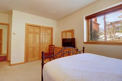 a bedroom with a bed and a window and a television at 172 Sauterne Sanctuary Townhouse in Silverthorne