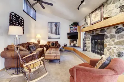 a living room with a stone fireplace at Cc301 Cross Creek Condo in Frisco