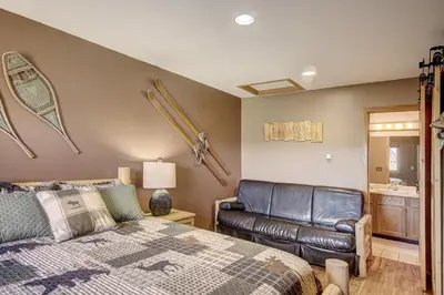 a bedroom with a bed and a leather couch at 315 Woodbridge Condo in Frisco