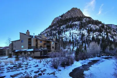 a building in front of a snow covered mountain at 315 Woodbridge Condo in Frisco