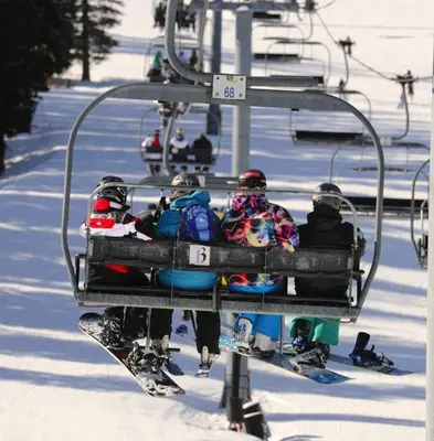 a group of people riding a ski lift in the snow at 315 Woodbridge Condo in Frisco