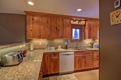 a kitchen with wooden cabinets and white appliances at 315 Woodbridge Condo in Frisco